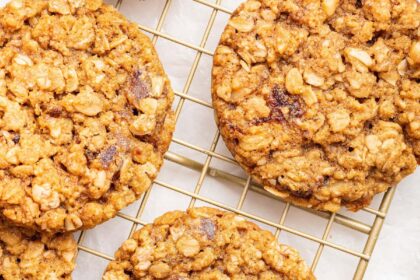 Oatmeal date cookies on a gold wire cooling rack.