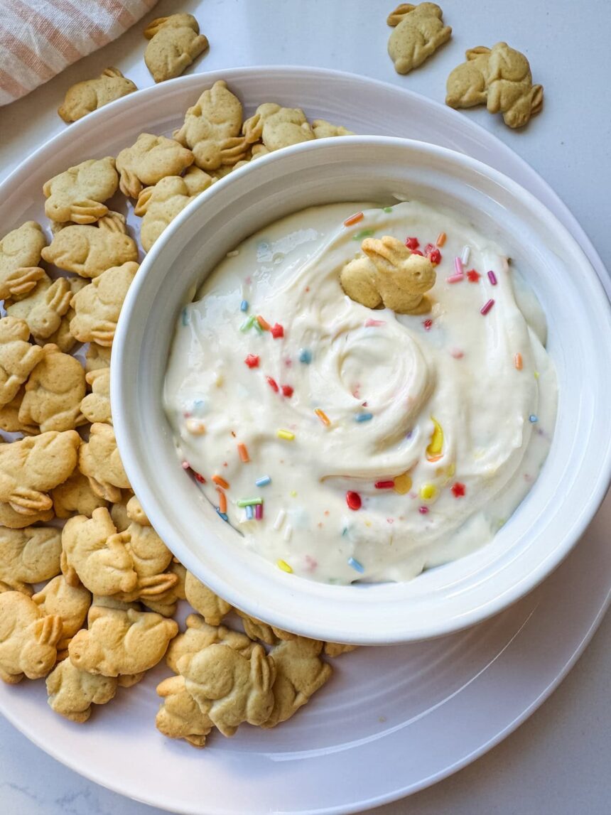 Protein Dunkaroo dip in a white bowl with bunny crackers on the side.